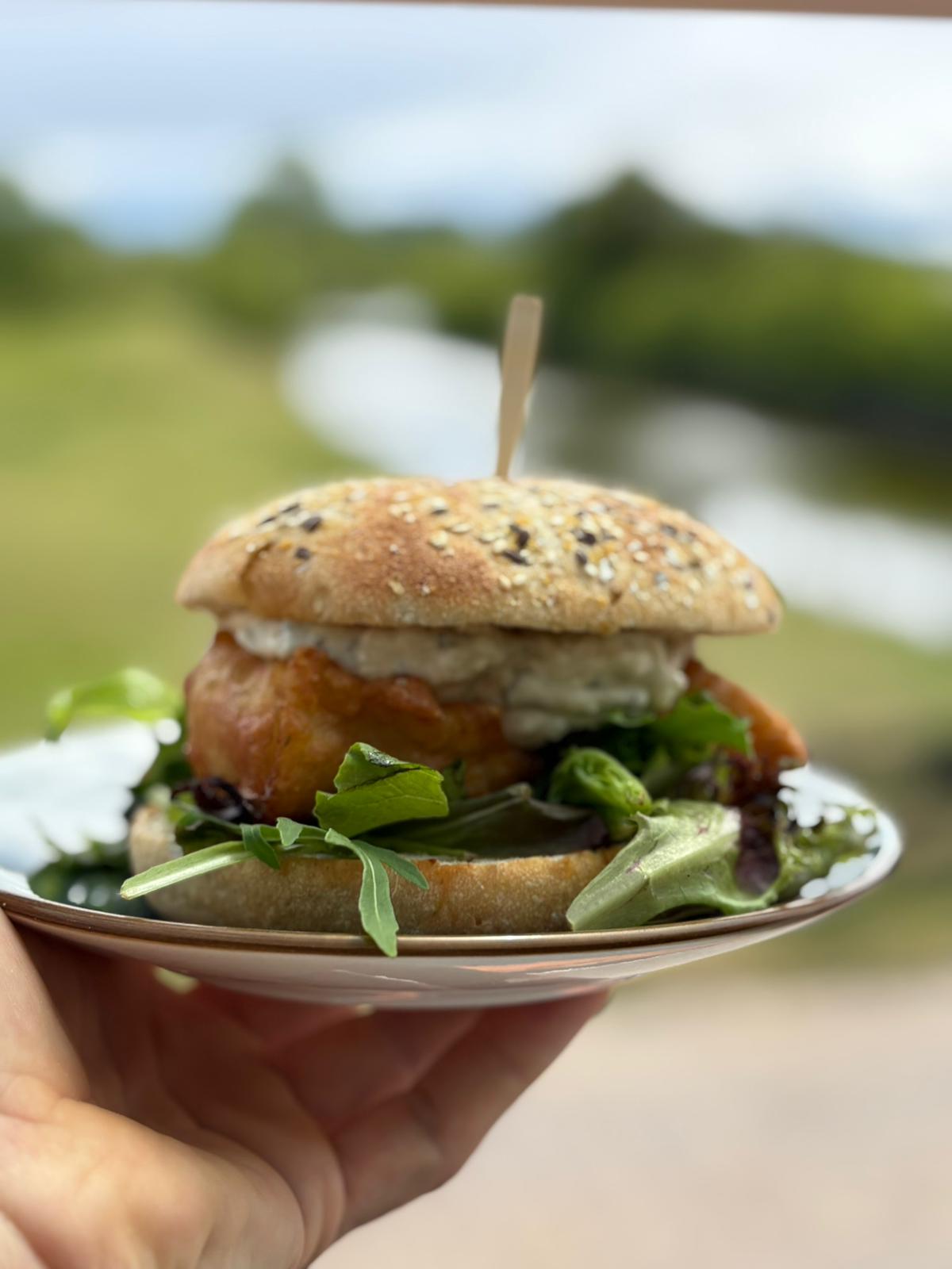 Verse vissandwich op meergranenbroodje met salade buiten geserveerd